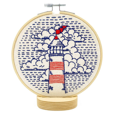 Embroidery hoop with a lighthouse design on a white background design with printed fabric, hoop, floss, needle & eco-friendly packaging
