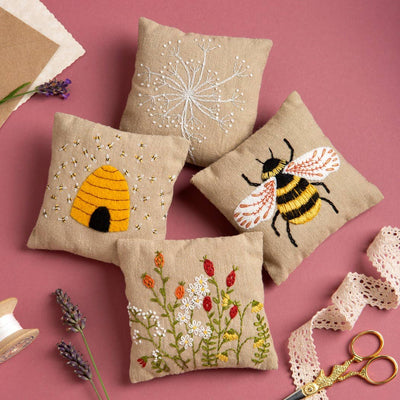 Embroidered pillows with bee and flower designs on a pink background
Linen Lavender Bags Embroidery Kit – Bees design – Complete DIY embroidery kit with pre-printed linen, threads, needle, lavender, and instructions