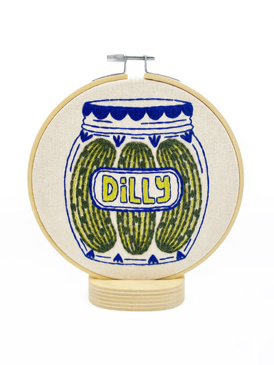 Embroidery hoop with a jar of pickles design and 'Dilly' text on a white background Hook, Line & Tinker Pickles Embroidery Kit – DIY embroidery kit featuring a jar of pickles design, with printed cotton fabric, 6″ hoop, floss, needle & instructions – beginner friendly