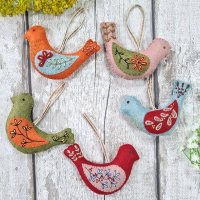 Colorful bird-shaped decorations on a wooden surface
Folk Birds Felt Craft Kit – Complete DIY sewing kit with felt, thread, needle, stuffing, and instructions to make colourful folk bird decorations