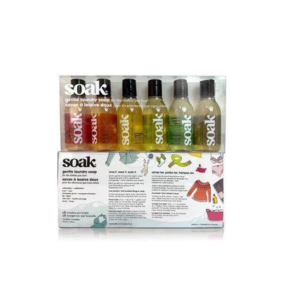 Soakbox Sampler – Assorted 90ml bottles of Soak no-rinse laundry detergent. A perfect gift set to try multiple scents of this eco-friendly fabric wash. Ideal for delicates, knits, and handmade items. Shop Soakbox at Purple Stitches. SKU: SOAKBOX-90ML-ASSORTED
Packaging of Soak gentle laundry soap with bottles on a white background