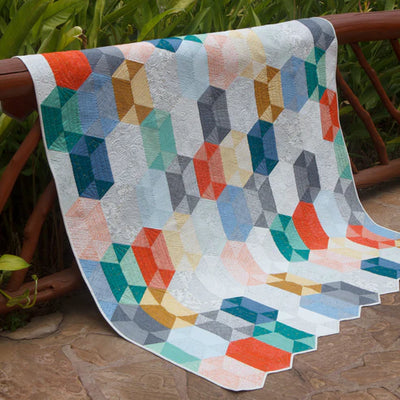 Disco Quilt made using the Jaybird Quilts printed pattern, SKU: JQP138. Features bold 3D geometric blocks with a cascading illusion. Shown in bright modern colours using the Botanics collection by Carolyn Friedlander. A stunning no Y-seam quilt pattern suitable for various sizes.