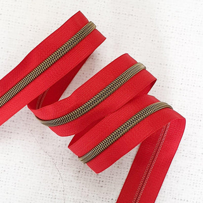 Poppy Red Zipper Tape with Antique Brass Coil Teeth - Size 5 Zip - Shop online and in store at Purple Stitches, Basingstoke, Hampshire UK